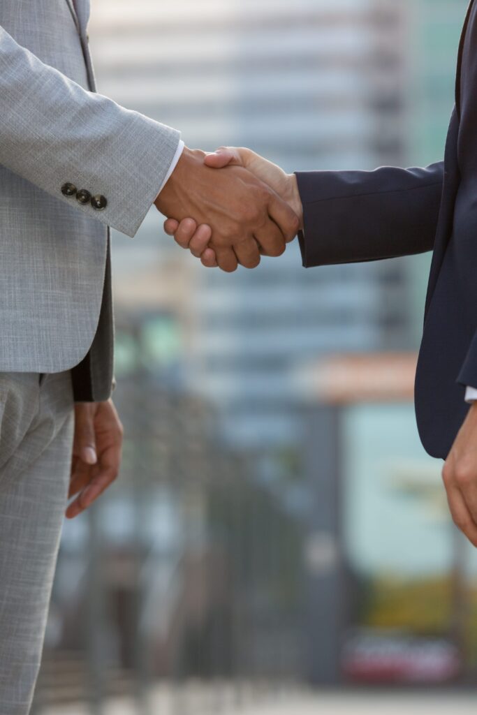 businesspeople standing city street shaking hands (1) (1)